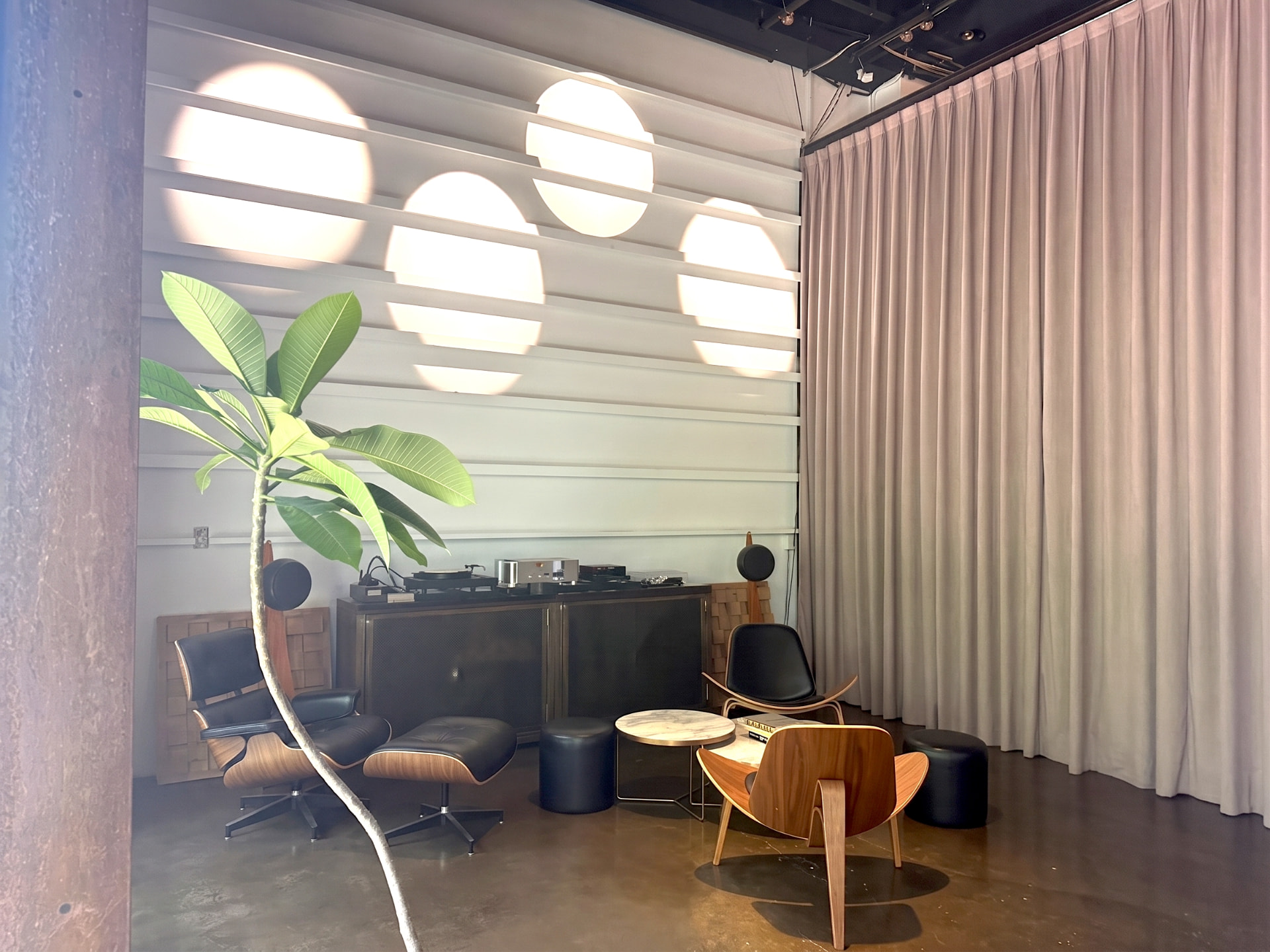 The listening corner of A39-1: leather lounge chairs, a hi-fi console, and a small tree in warm light